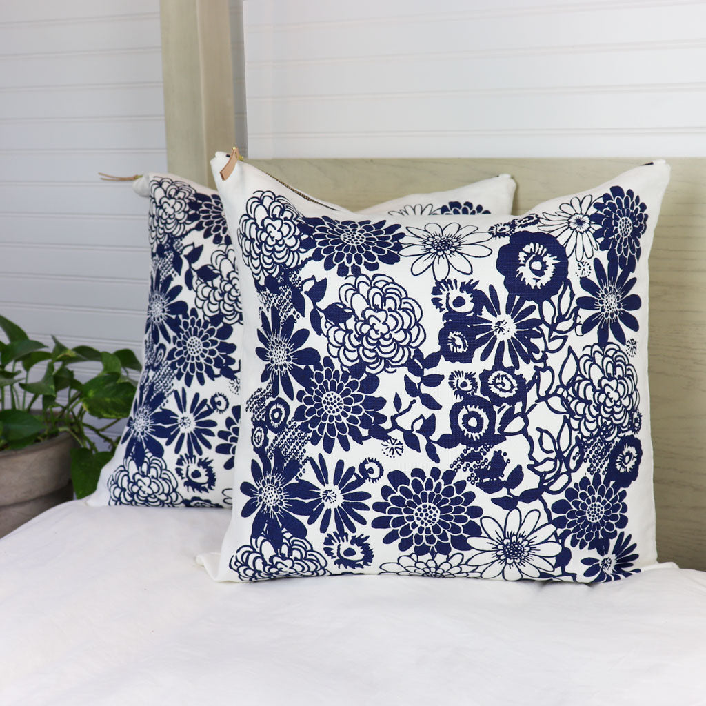 https://princeandpom.com/cdn/shop/products/White-and-Navy-Blue-Flowers-Decorative-Throw-Pillow-on-Bed_1445x.jpg?v=1652810399